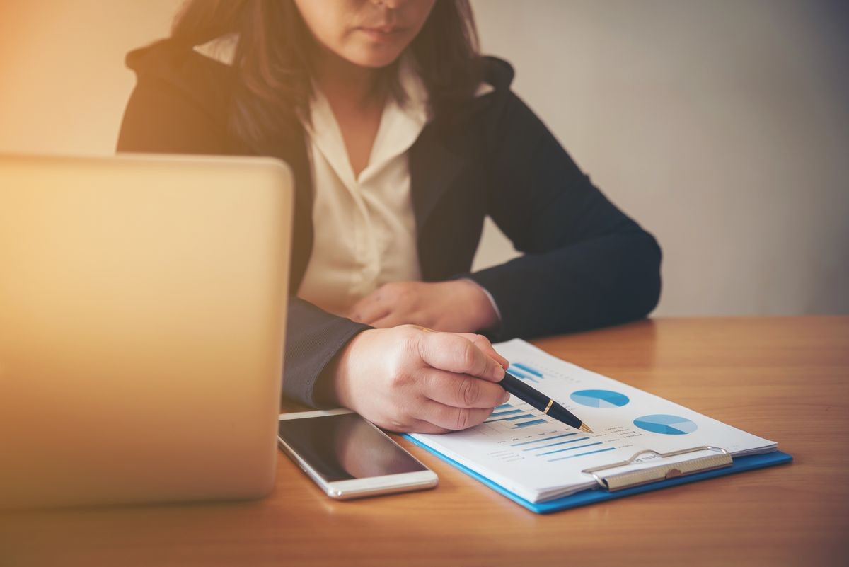 woman hand with pen and business report. Accounting